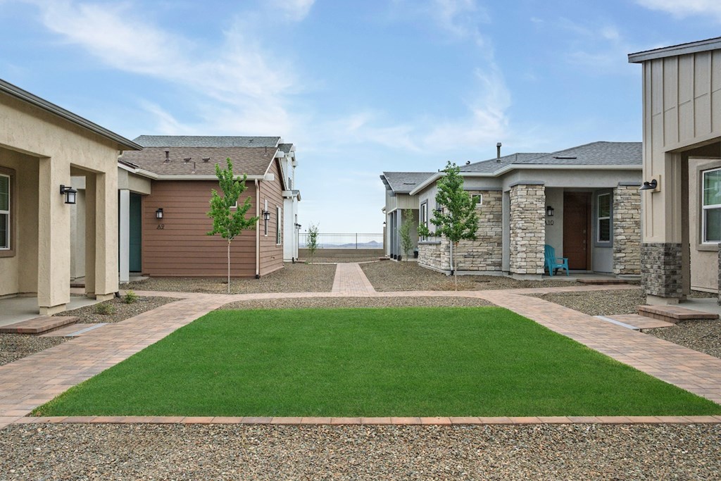 A row of houses with a green lawn in the foreground.