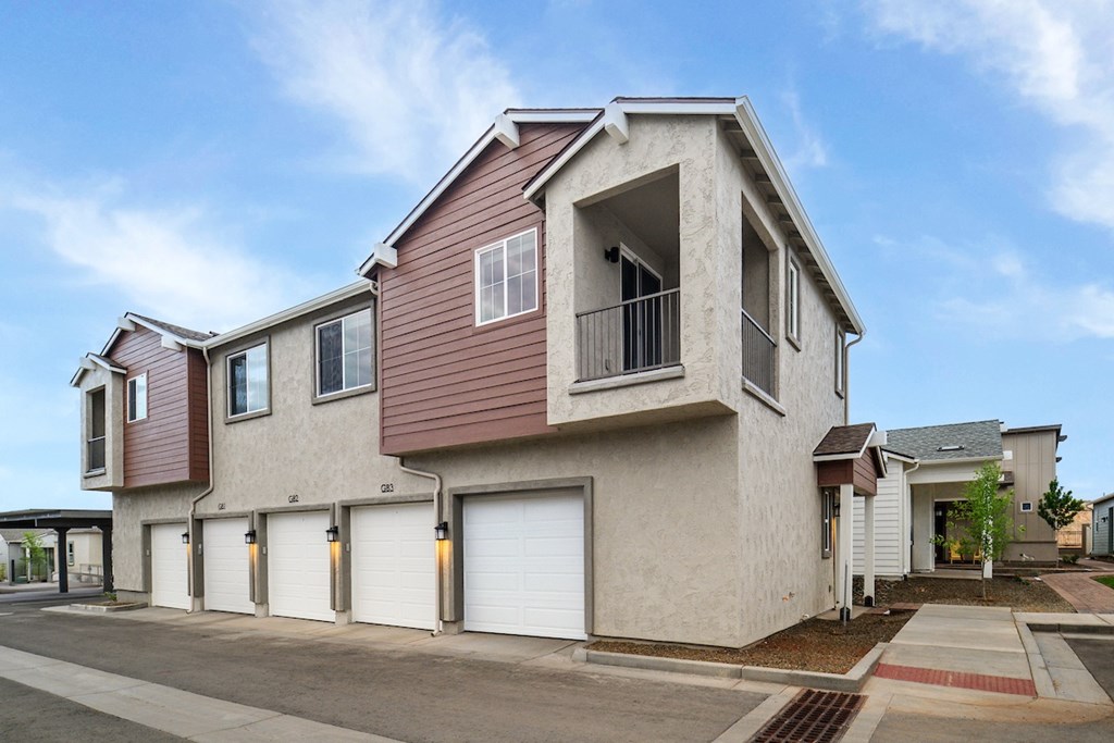A modern two-story house with a garage and a balcony.