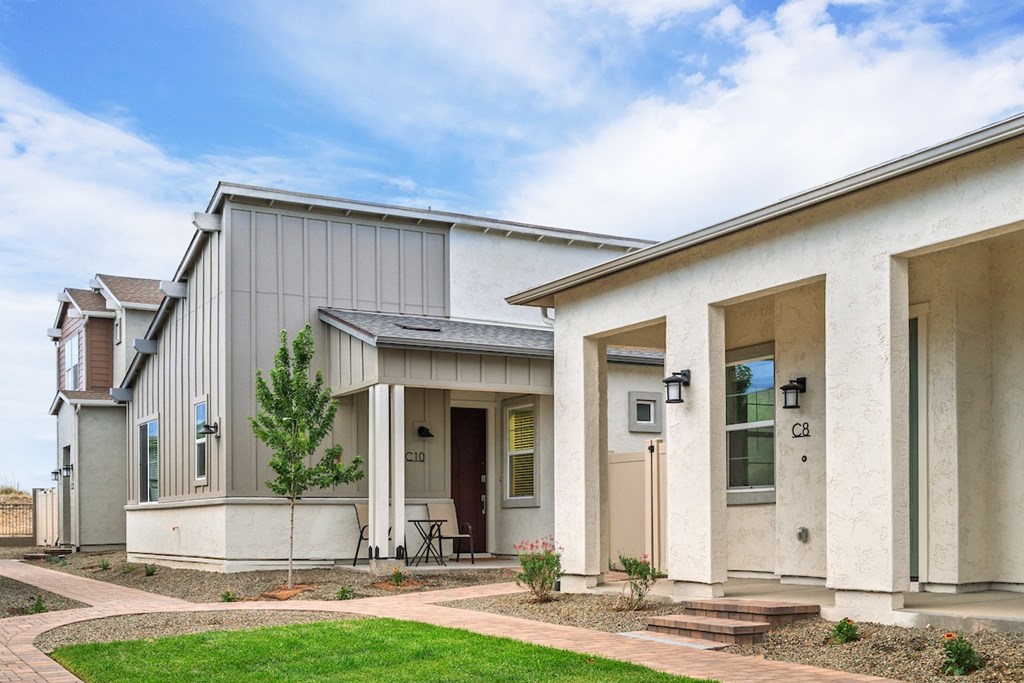 A modern house with a grey exterior and a brown door.