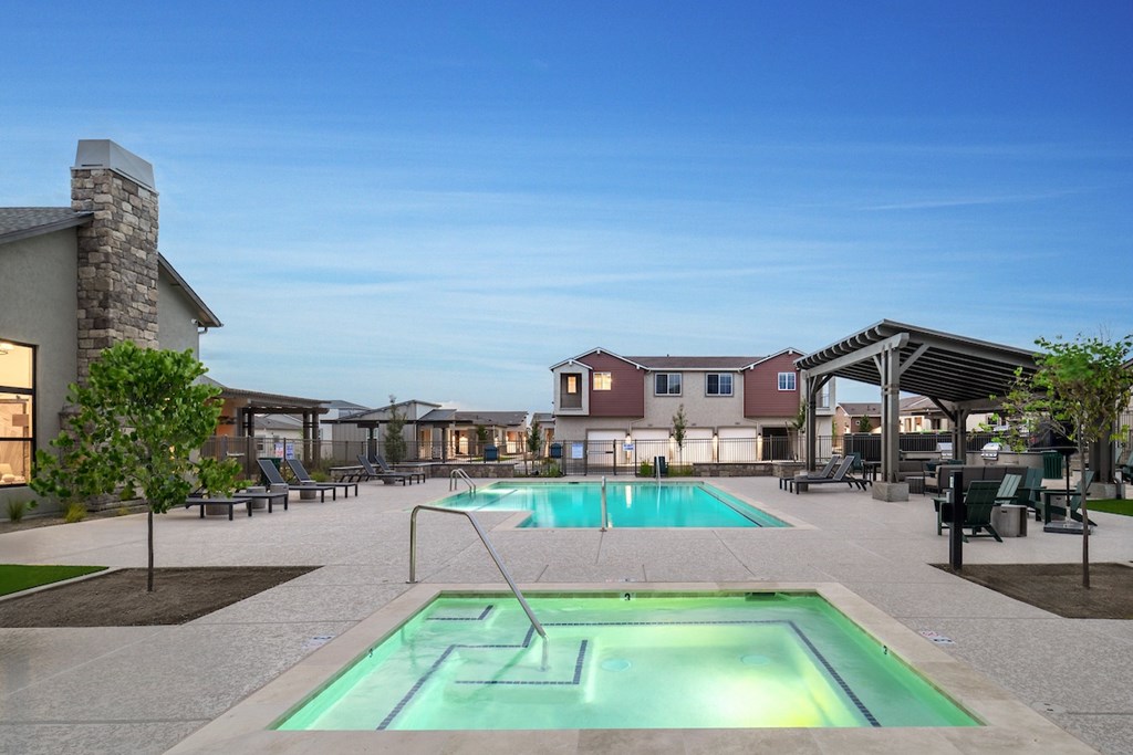 A swimming pool with a greenish hue in the middle of a residential area.