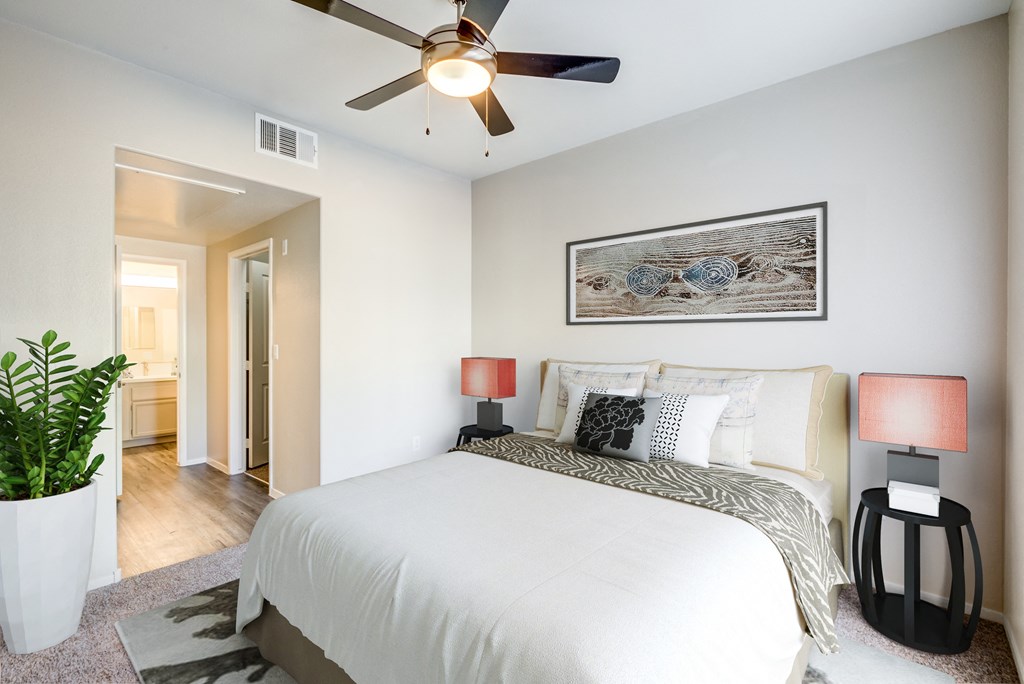 a bedroom with a large bed and a ceiling fan