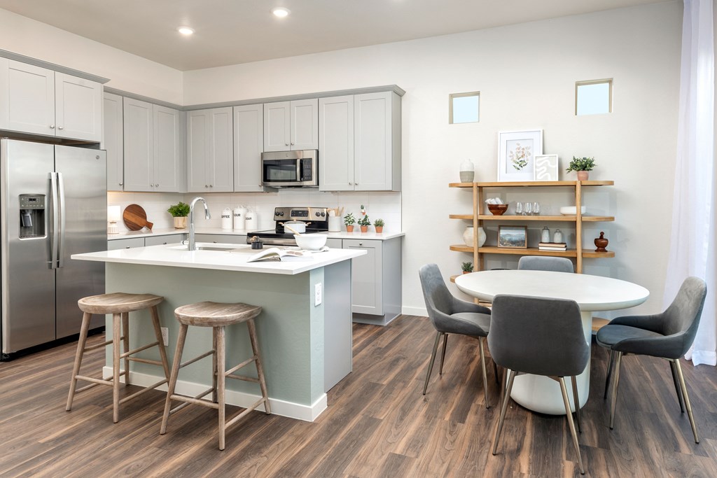 a kitchen and dining area with a table and chairs and a refrigerator