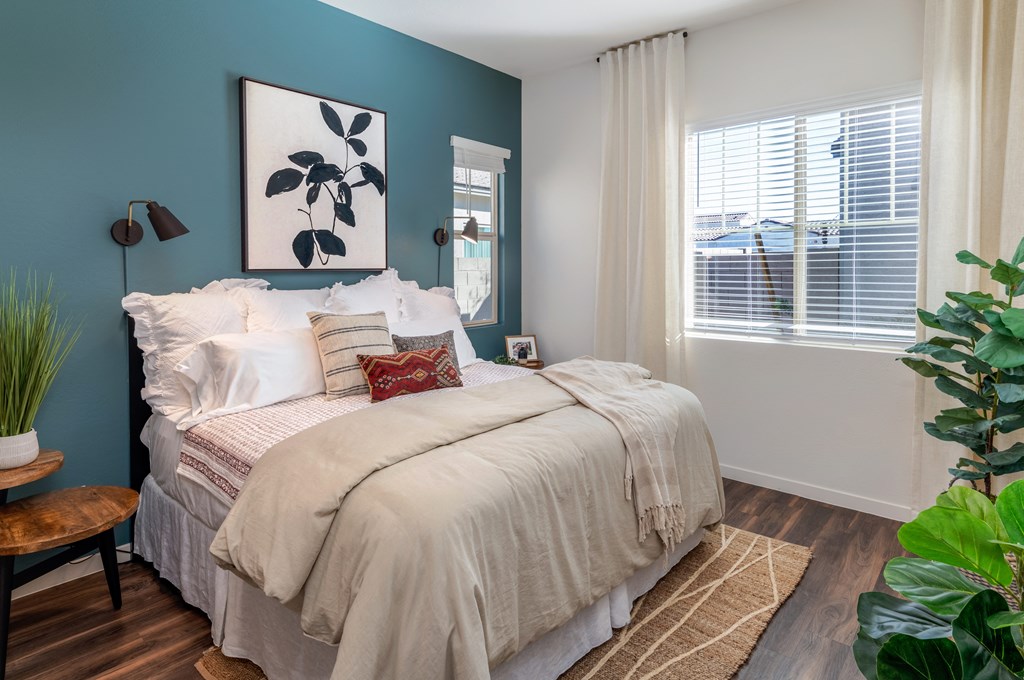 a bedroom with blue walls and a bed with white blankets and pillows