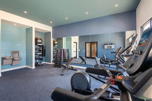 a gym with exercise equipment and mirrors in a building