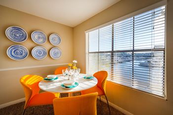 a dining room with a table and chairs and a large window
