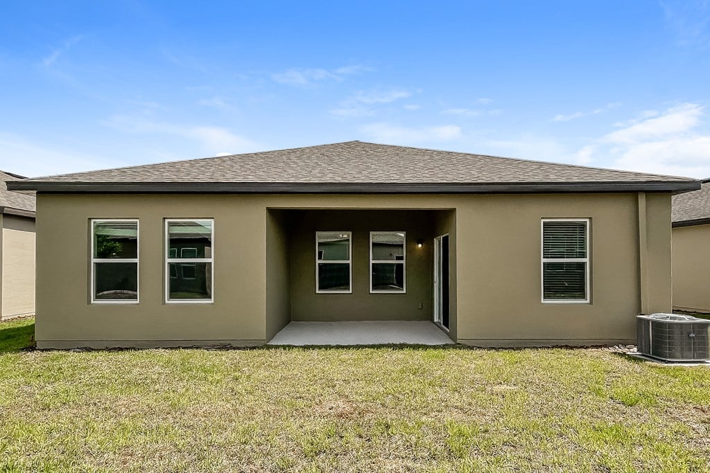 A house with a brown roof and a brown wall with a white door and windows.