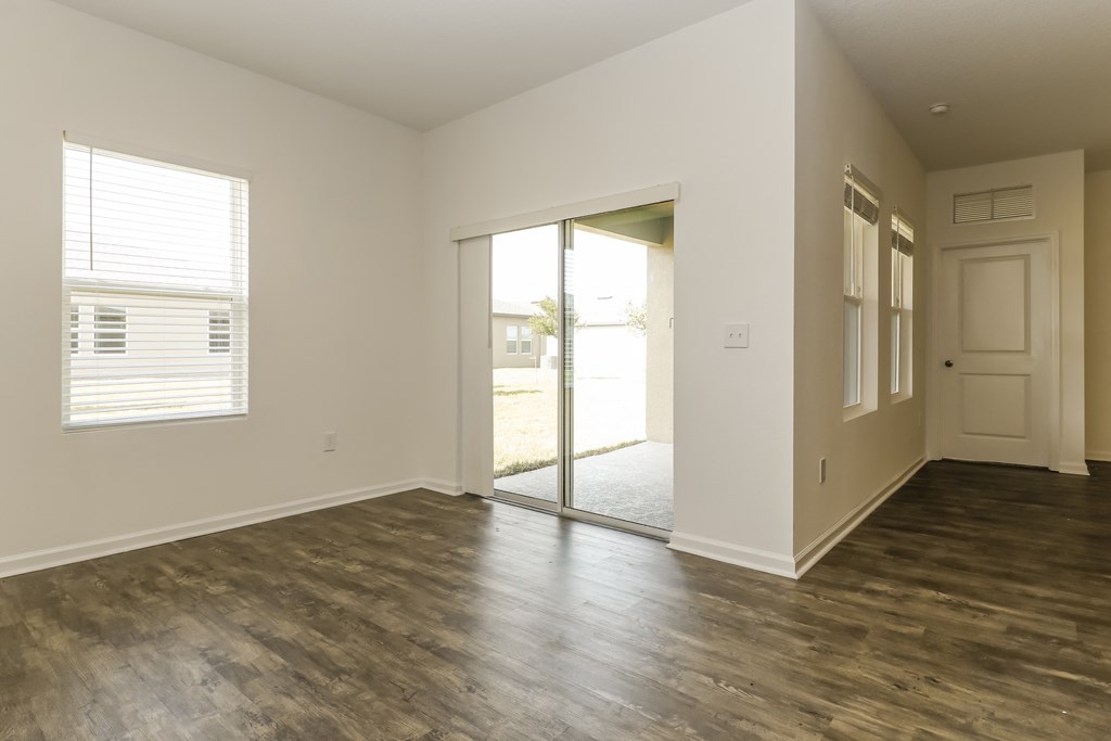A room with a sliding glass door leading to a balcony.