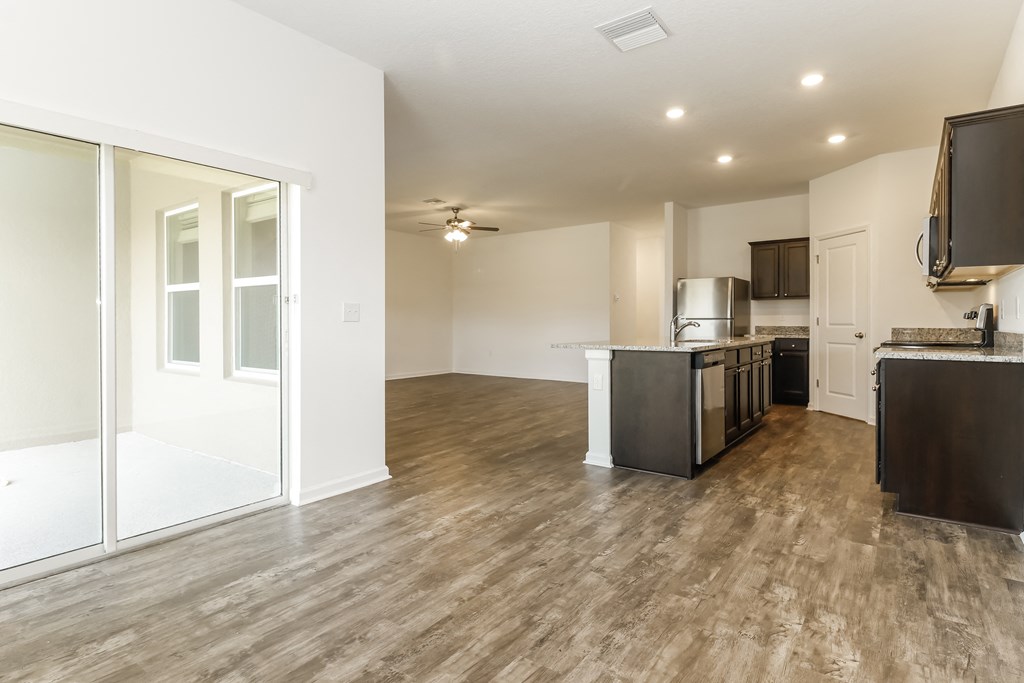 A kitchen with a refrigerator, microwave, and oven.
