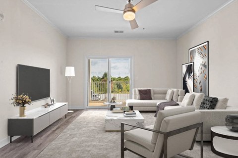 A living room with a flat screen TV, a sofa set, a coffee table, and a ceiling fan.