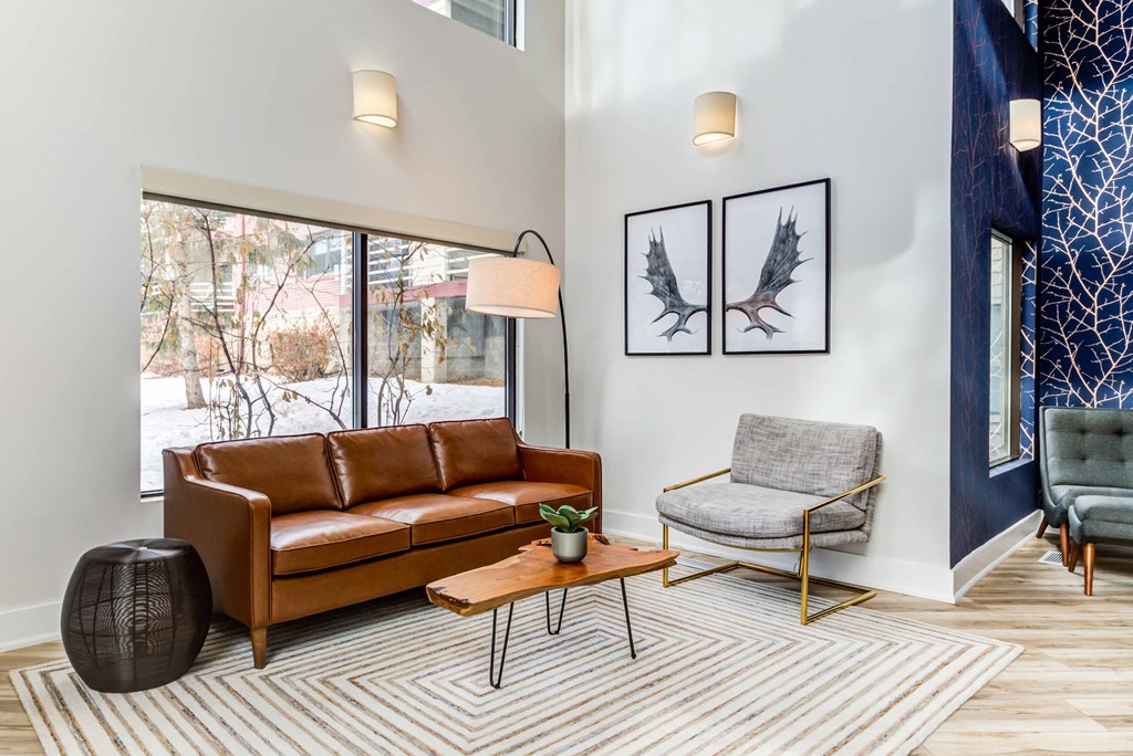 a living room with a leather couch and a chair