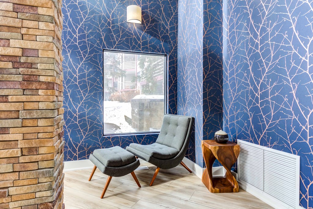 a living room with blue wallpaper and two chairs
