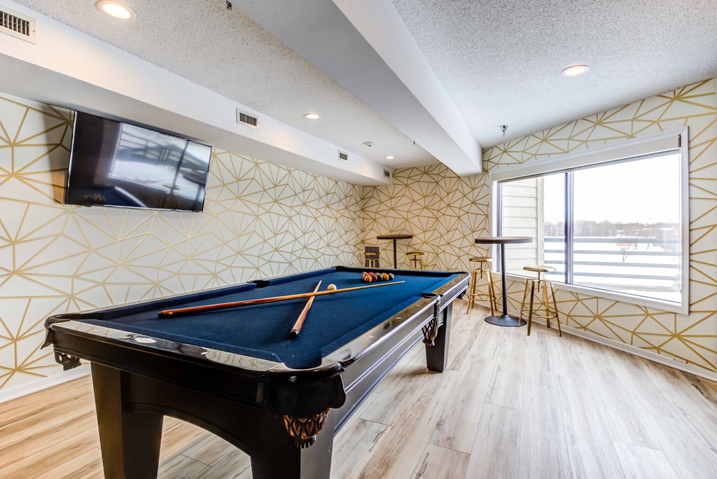 a pool table in a game room with a tv