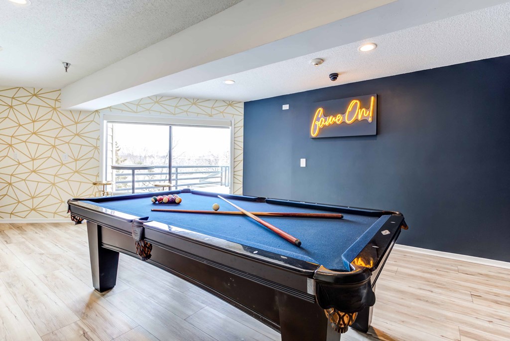 a pool table in the game room of a house with a pool
