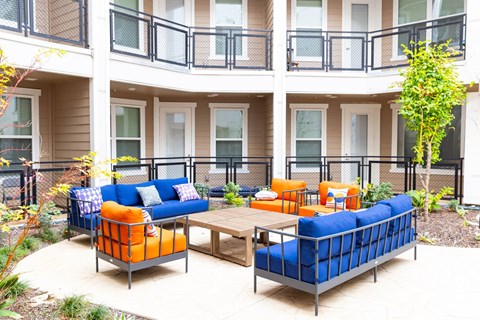 a patio with couches and a table outside of a building