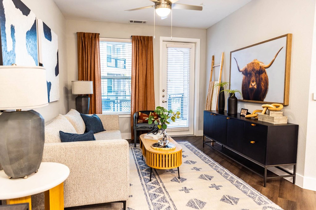 a living room with a couch and a television and a painting of a bull