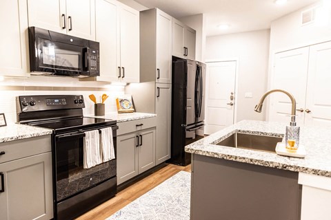 a kitchen with black appliances and granite counter tops