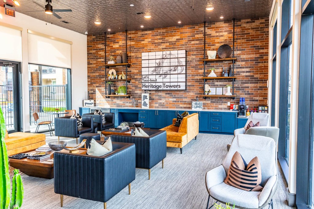 a living room with blue furniture and a brick wall