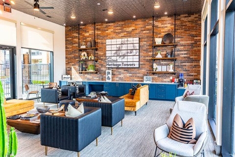 a living room with blue furniture and a brick wall