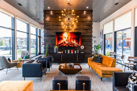 a living room with a fireplace and seating in front of a window