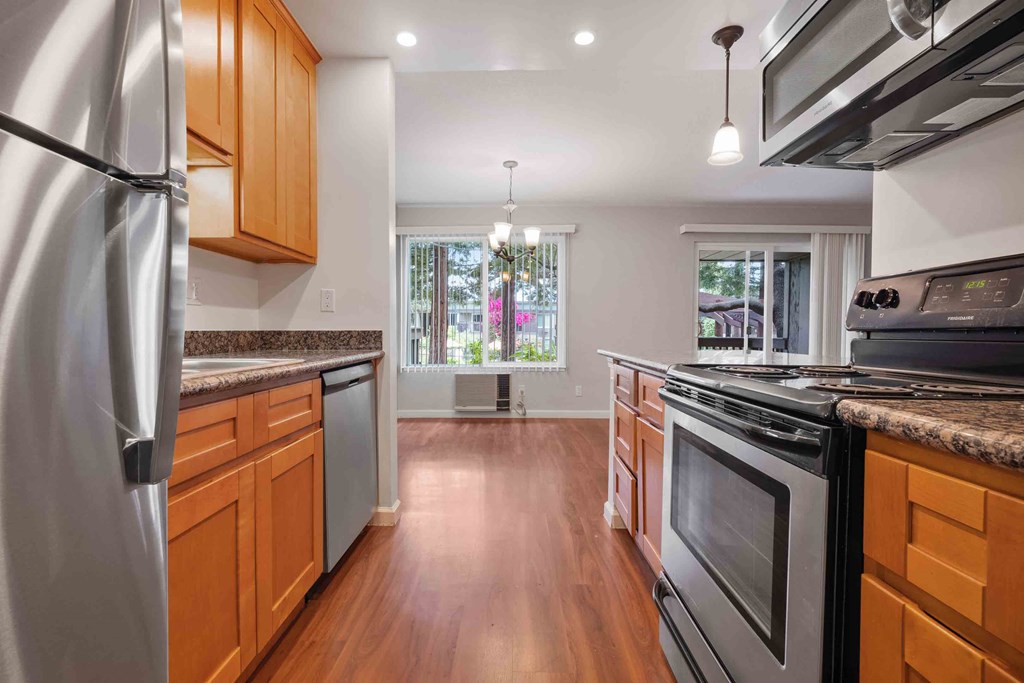 Apartments for Rent in Santa Clara, CA - Hidden Lake - Kitchen with Wood-Style Flooring, Granite-Style Countertops, Wood Cabinets, and Stainless Steel Appliances