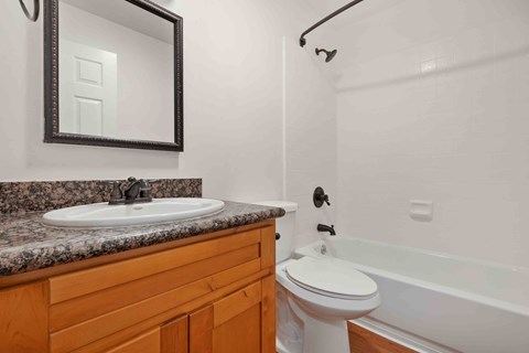 Dog-Friendly Apartments in Santa Clara, CA - Hidden Lake - Bathroom with Shower and Bathtub Combo with White Tile, Vanity with Wood-Style Cabinets and Granite Countertop.