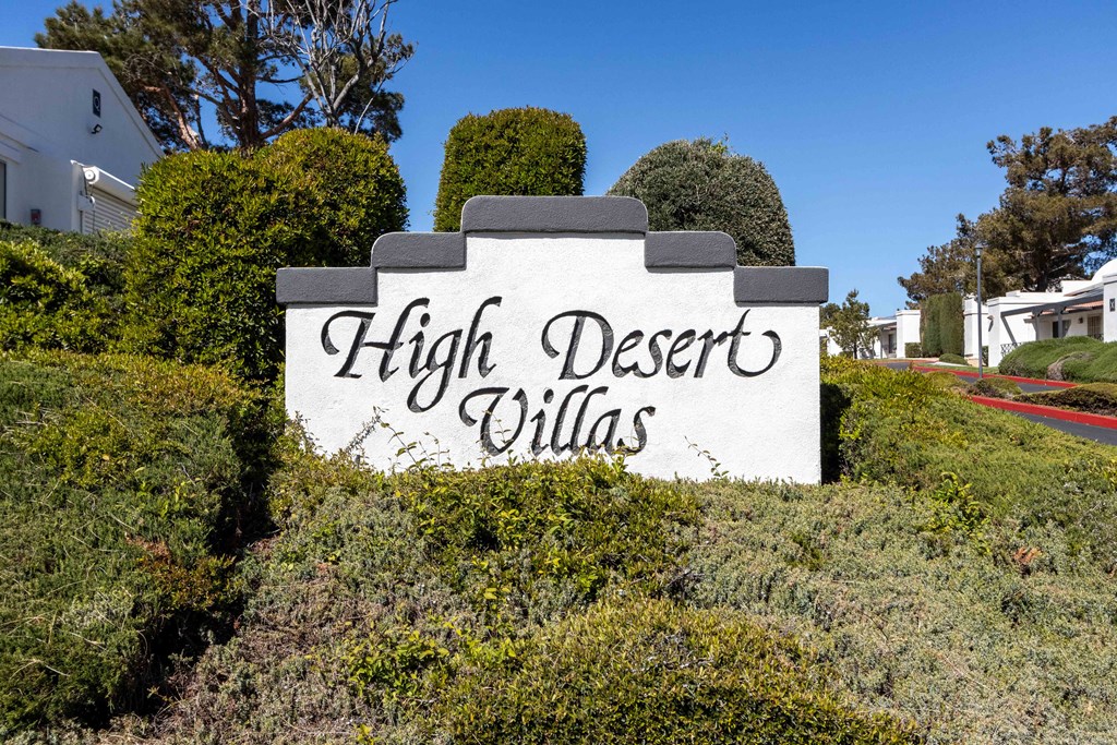 High Desert Villas apartments in Victorville California the sign for high desert villas in front of bushes and trees