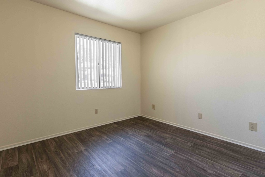 High Desert Villas apartments in Victorville California  the living room of an empty home with wood flooring and a window