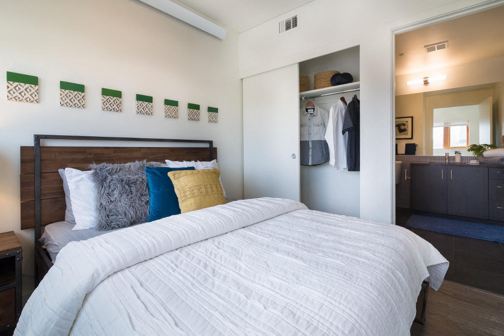 Portland, OR Apartments - Muse Apartments Bedroom With Stylish Decore, Large Closet and Access to Bathroom