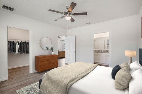 A bedroom with a large bed and a ceiling fan.