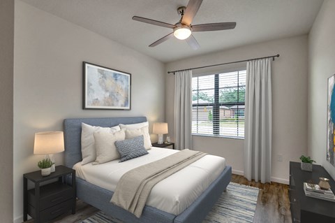 A bedroom with a bed, nightstands, and a ceiling fan.