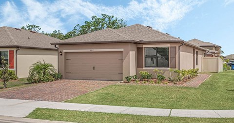 A house with a brown roof and a grey garage door.