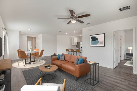 A living room with a brown couch and a ceiling fan.