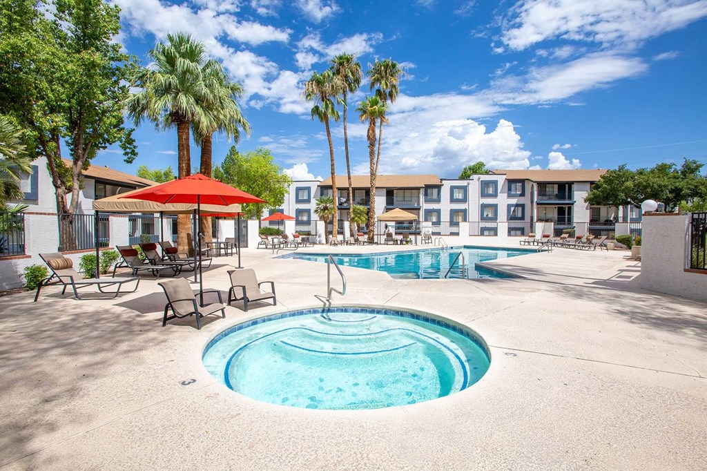 a resort style pool with palm trees and a building in the background
