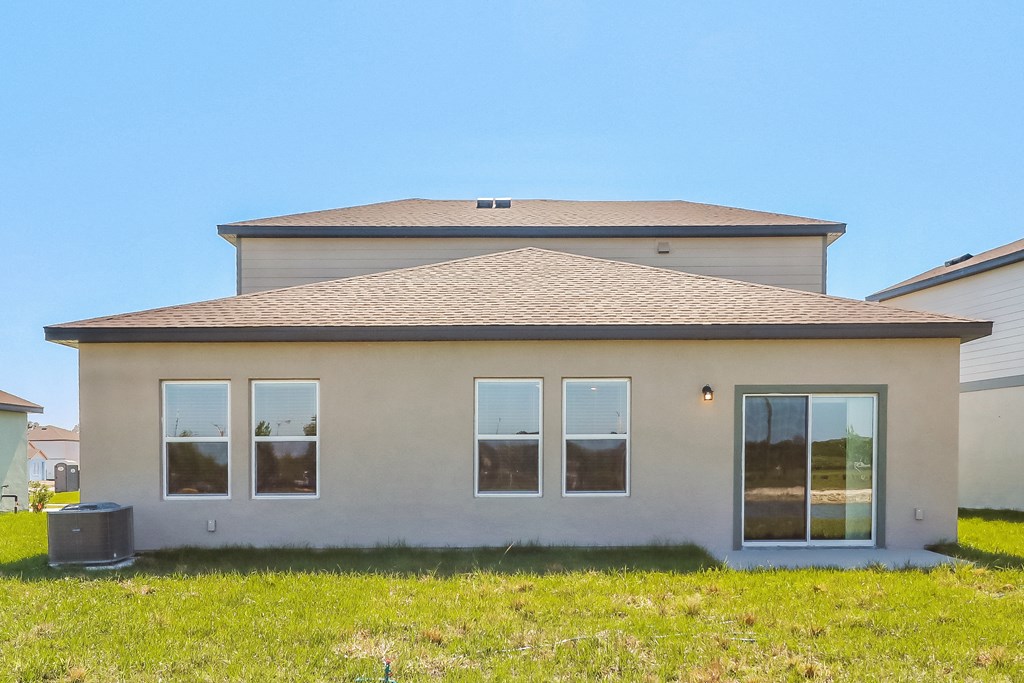 A house with a grey roof and beige walls with a window on the right side.