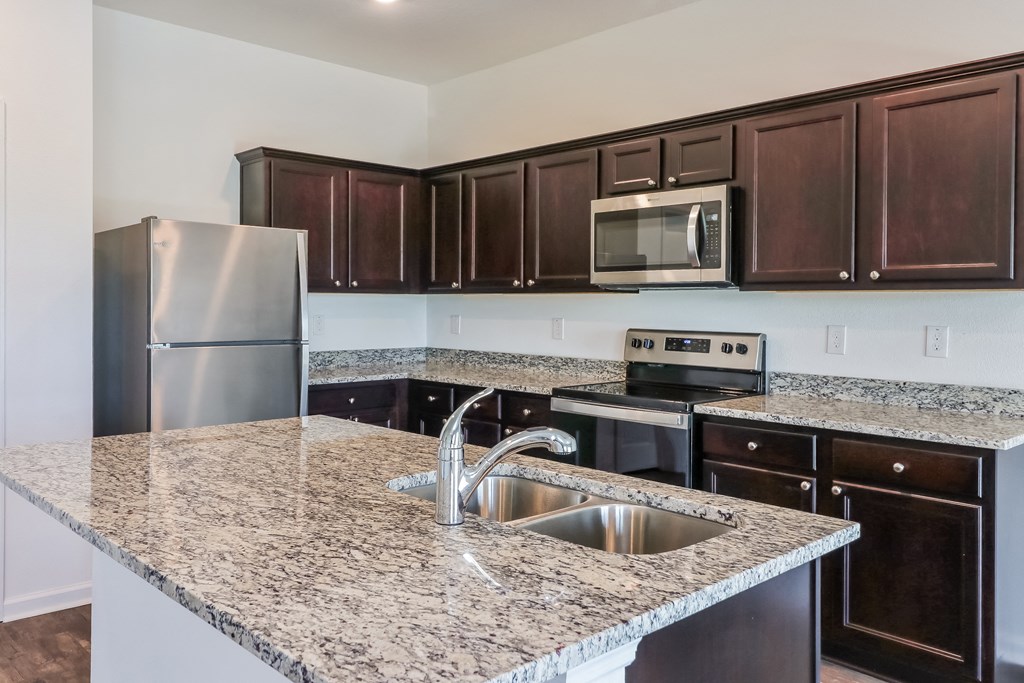 A kitchen with granite countertops and stainless steel appliances.