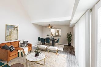 Hunters Pointe Apartments in Charlotte North Carolina photo of a living room and dining room with white walls and a ceiling fan - Photo Gallery 1