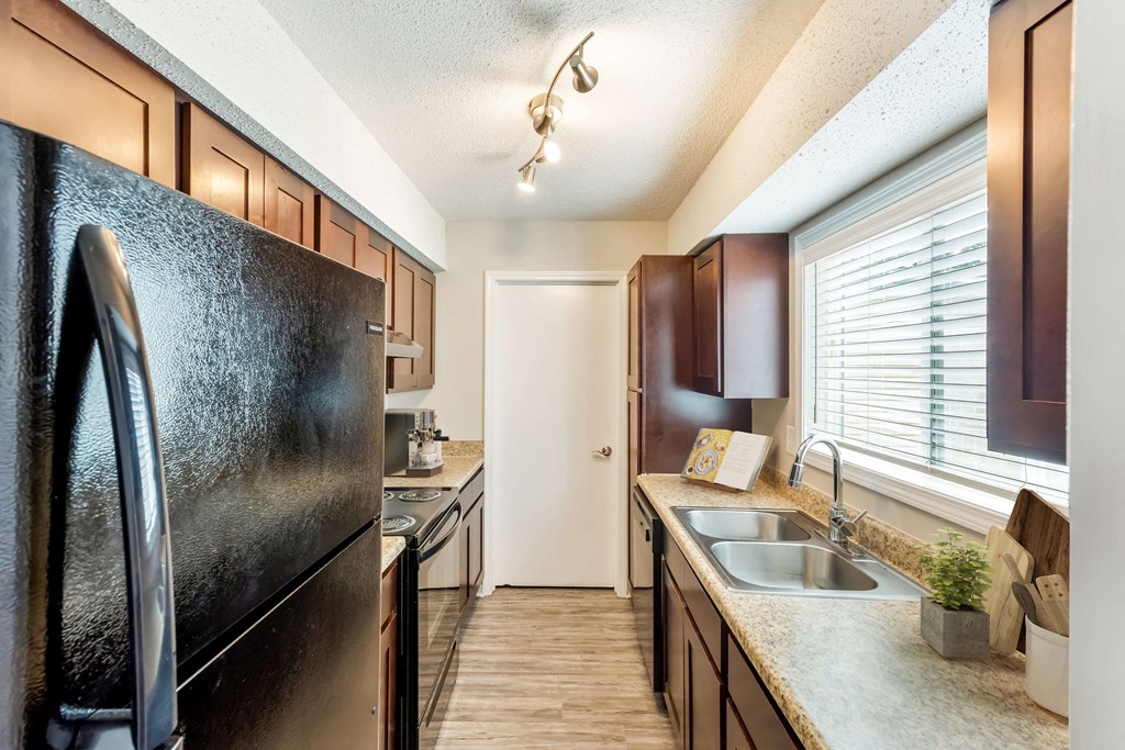 Modern kitchen with black appliances and sleek countertops at Hunters Pointe apartments in Charlotte, NC 28213, near UNC Charlotte