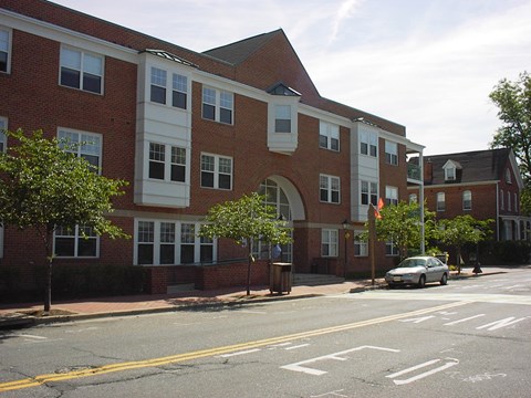 A street view of a building with a car parked in front.