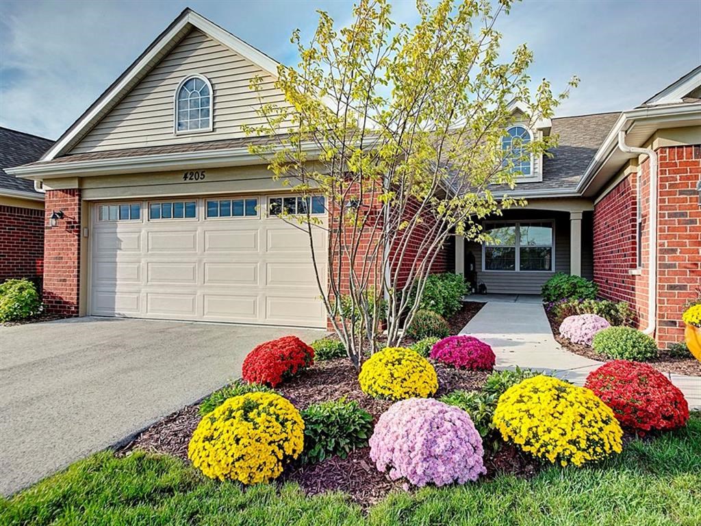 a house with a garden of colorful flowers in front of it