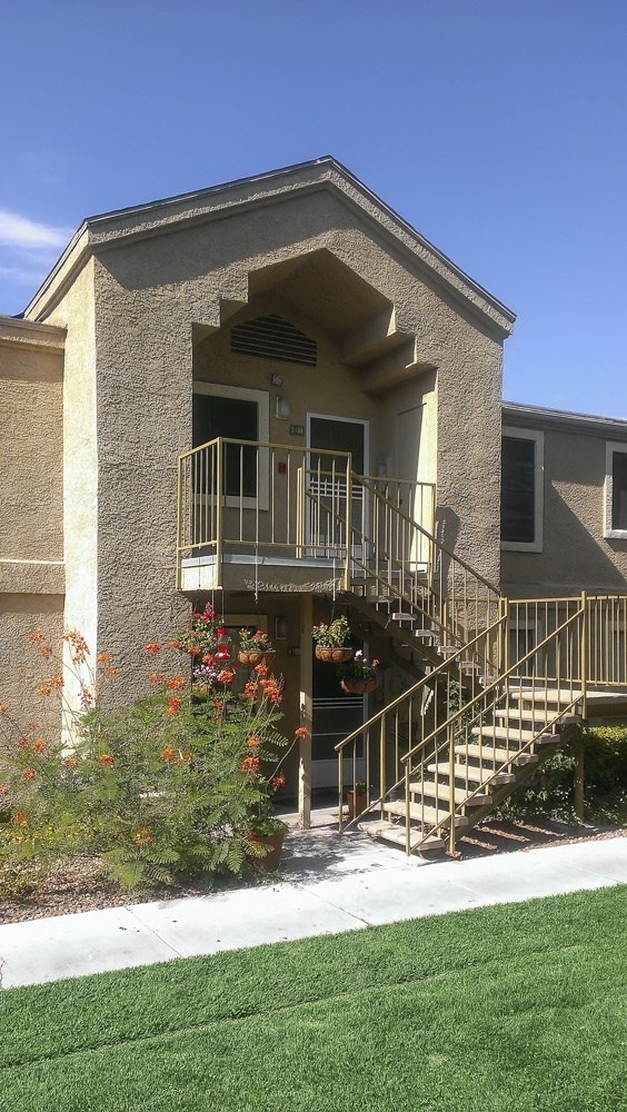 the front of a house with stairs and a balcony