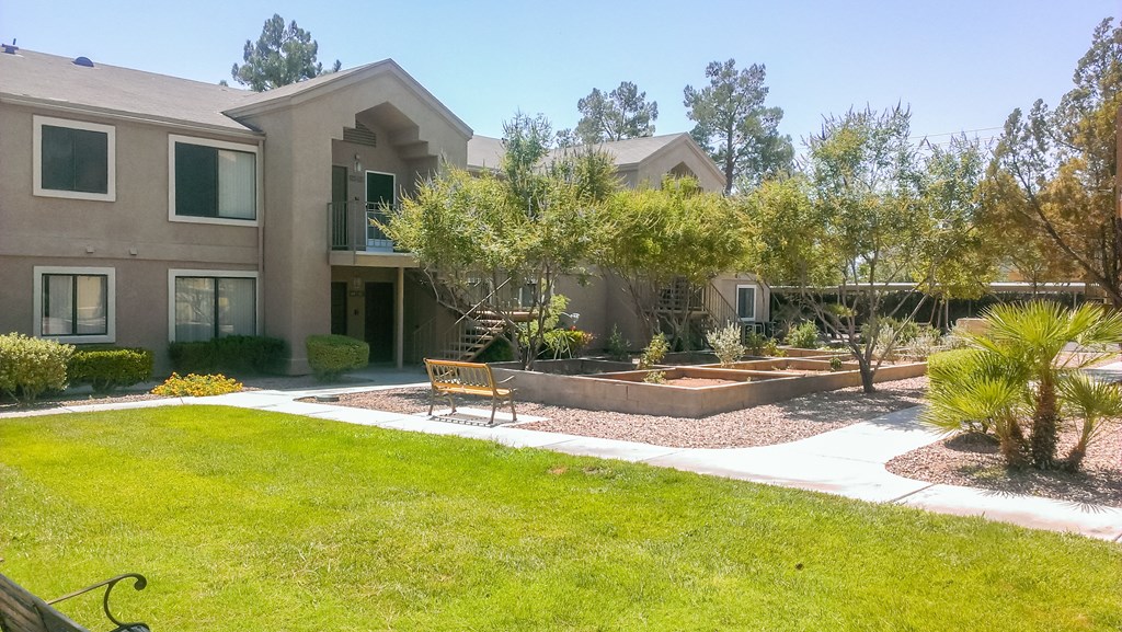 a garden with a bench in front of a house
