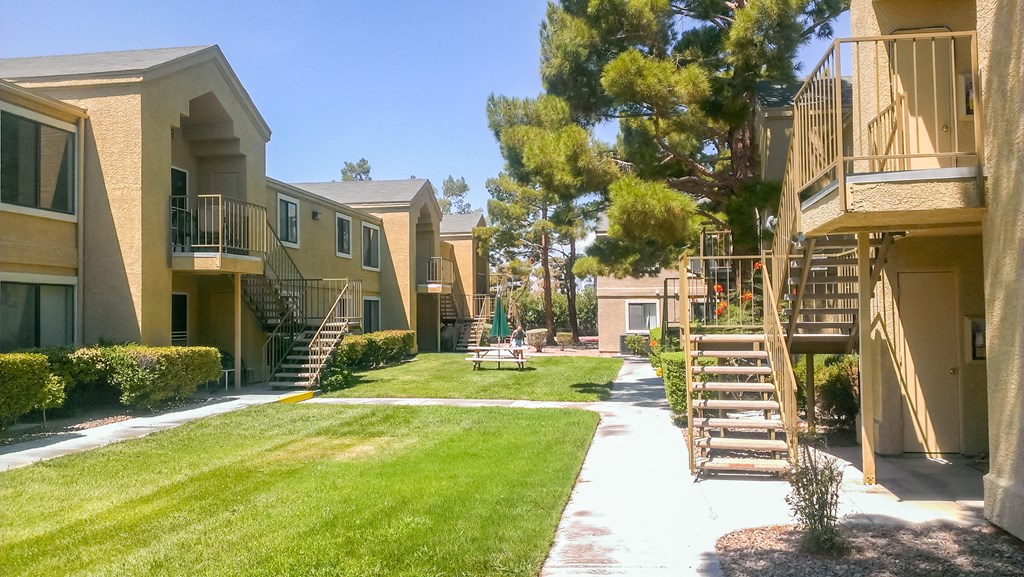 an outside view of an apartment building with lawn and stairs