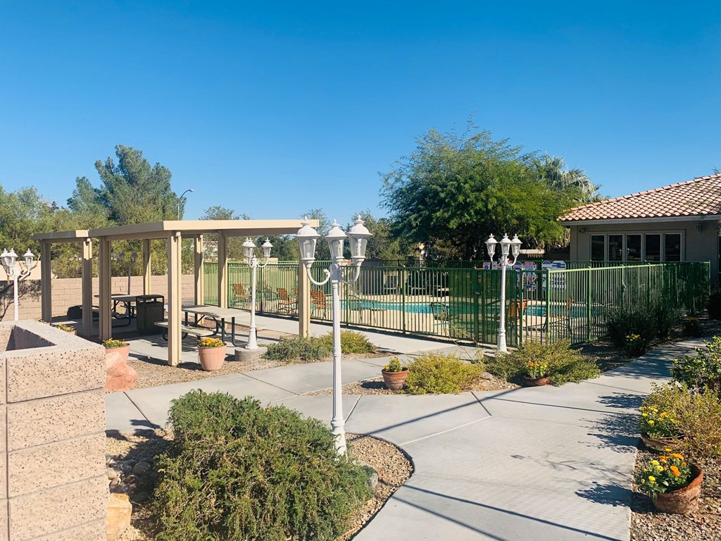 a patio with a fence and a pool in front of a house