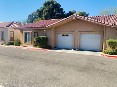 a house with two white garage doors and a driveway