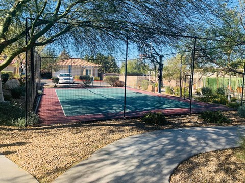 a tennis court in the backyard of a house with a fence