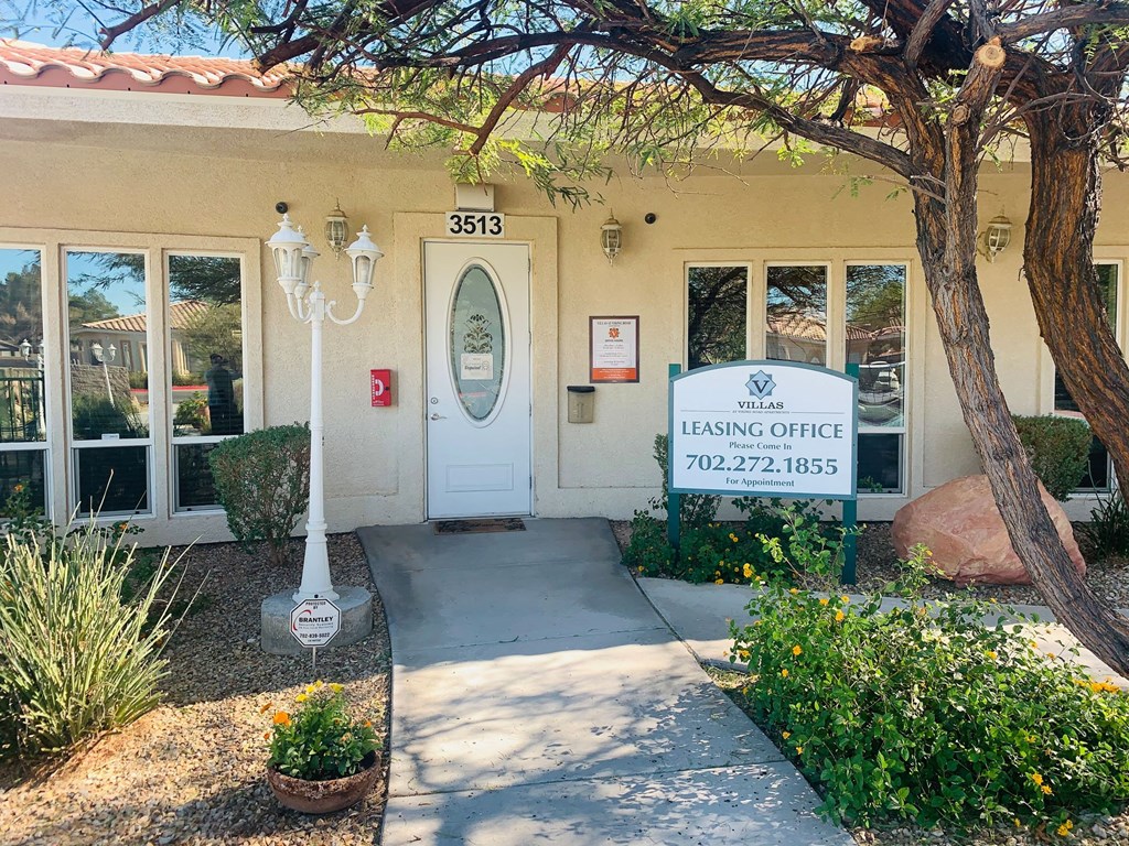 a building with a leasing office and a sign in front of it