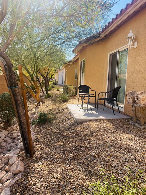 a patio with a table and chairs outside of a house
