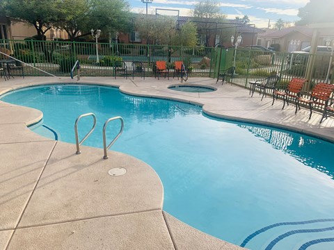 a resort style pool with chairs and a fence around it