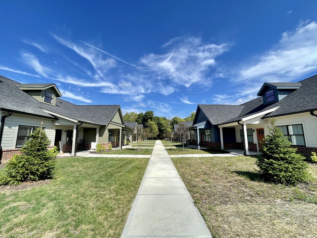 a row of houses with a long sidewalk in the middle of them
