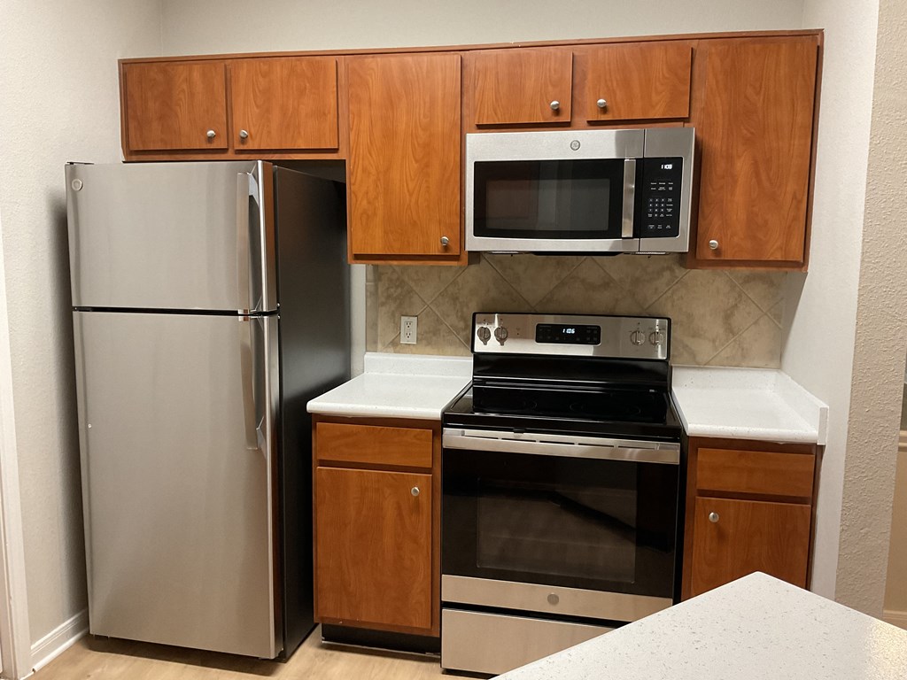 a kitchen with stainless steel appliances and wooden cabinets